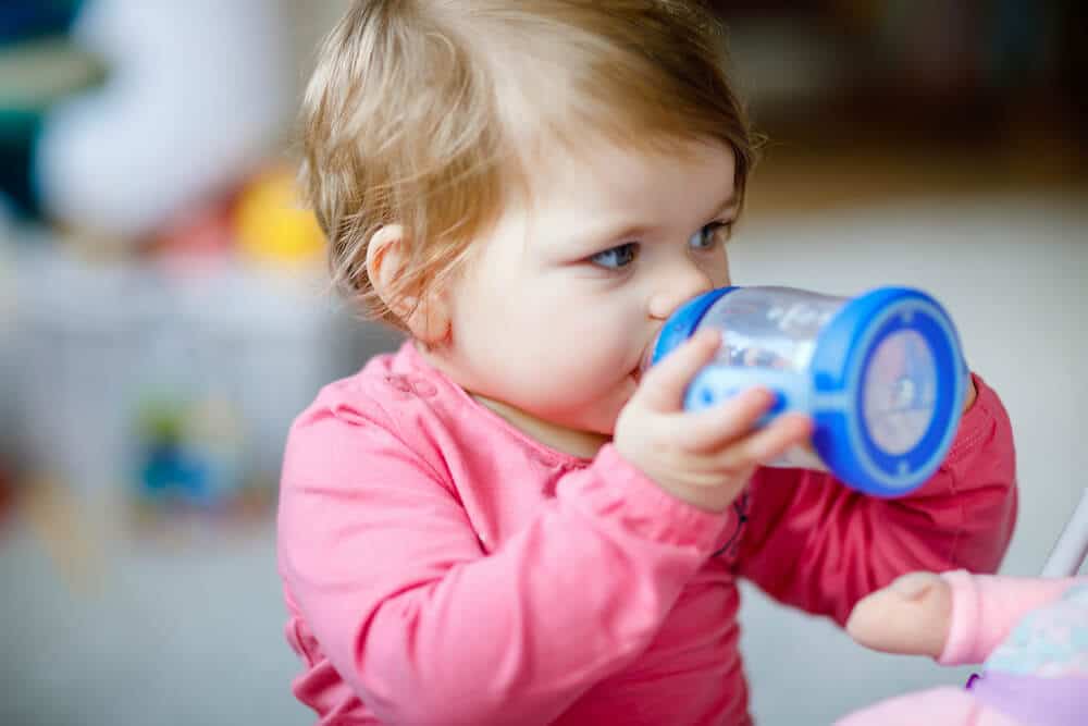 Baby girl drinking from milk bottle