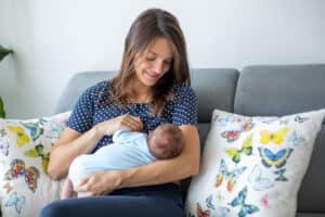 young mother breastfeeding her newborn baby boy