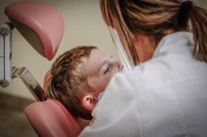 lady dentist doctor diagnosing the teeth health of child